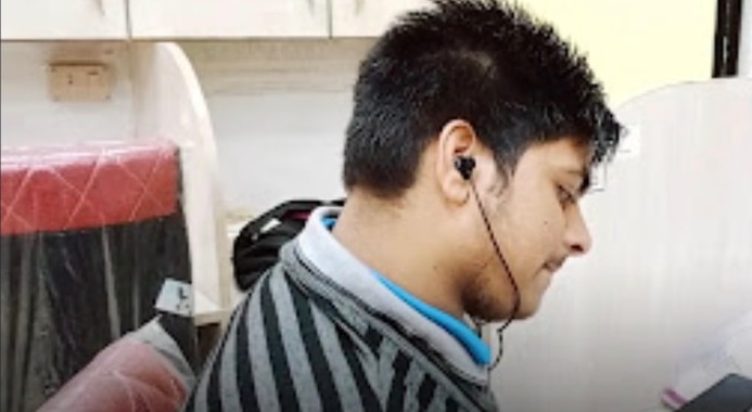 A member studying at a wide desk inside a personal cabin with a charging point at Library Hub, Guwahati